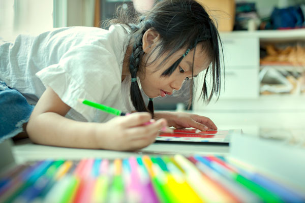 Asian children playing and painting color pencil on paper book in home school rWDMhfdPG
