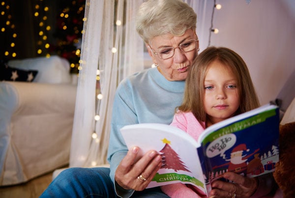 Grandmother and granddaughter reading a storybook together