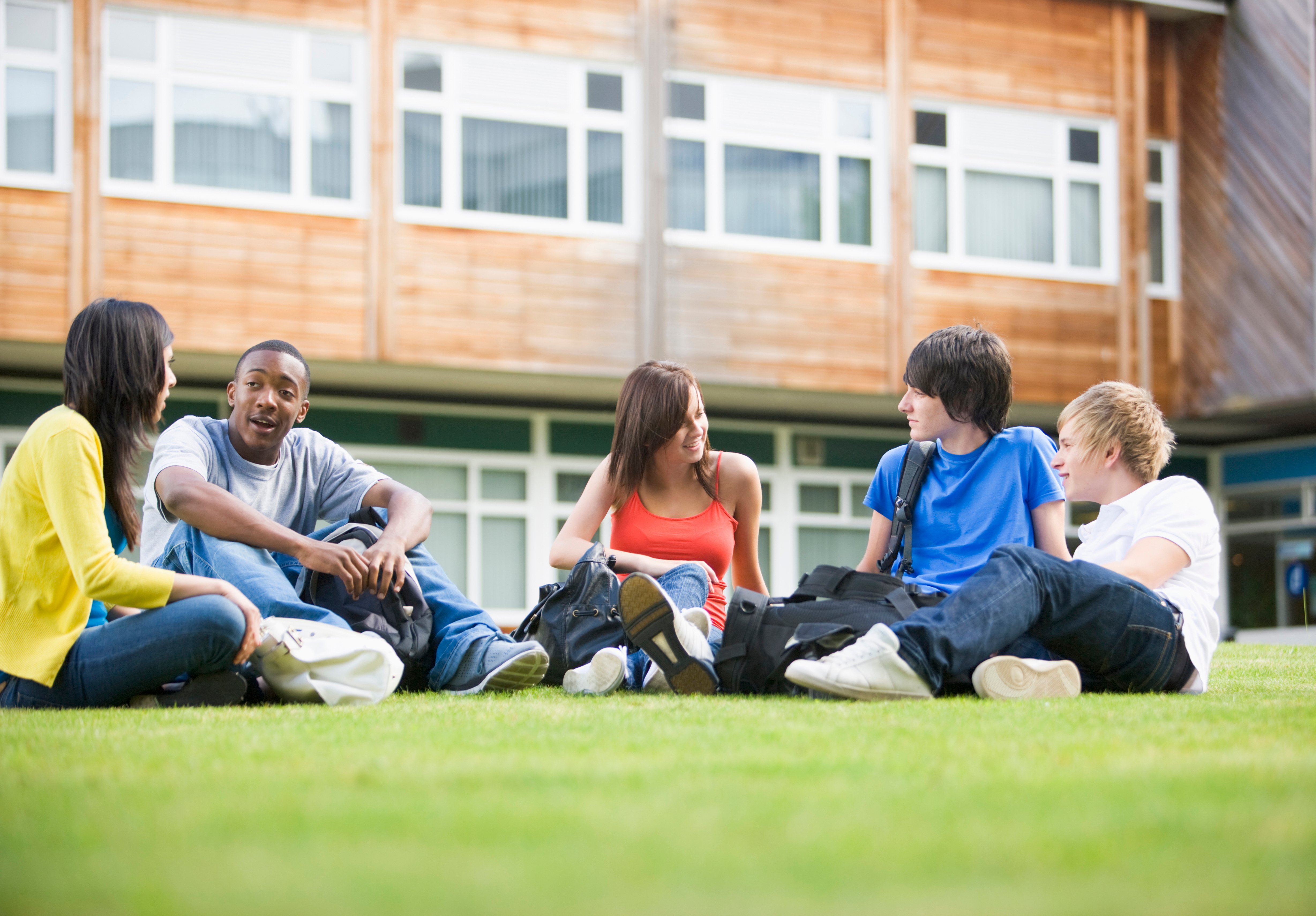 College Students Sitting And Talking On Campus Lawn Hfut06Abo