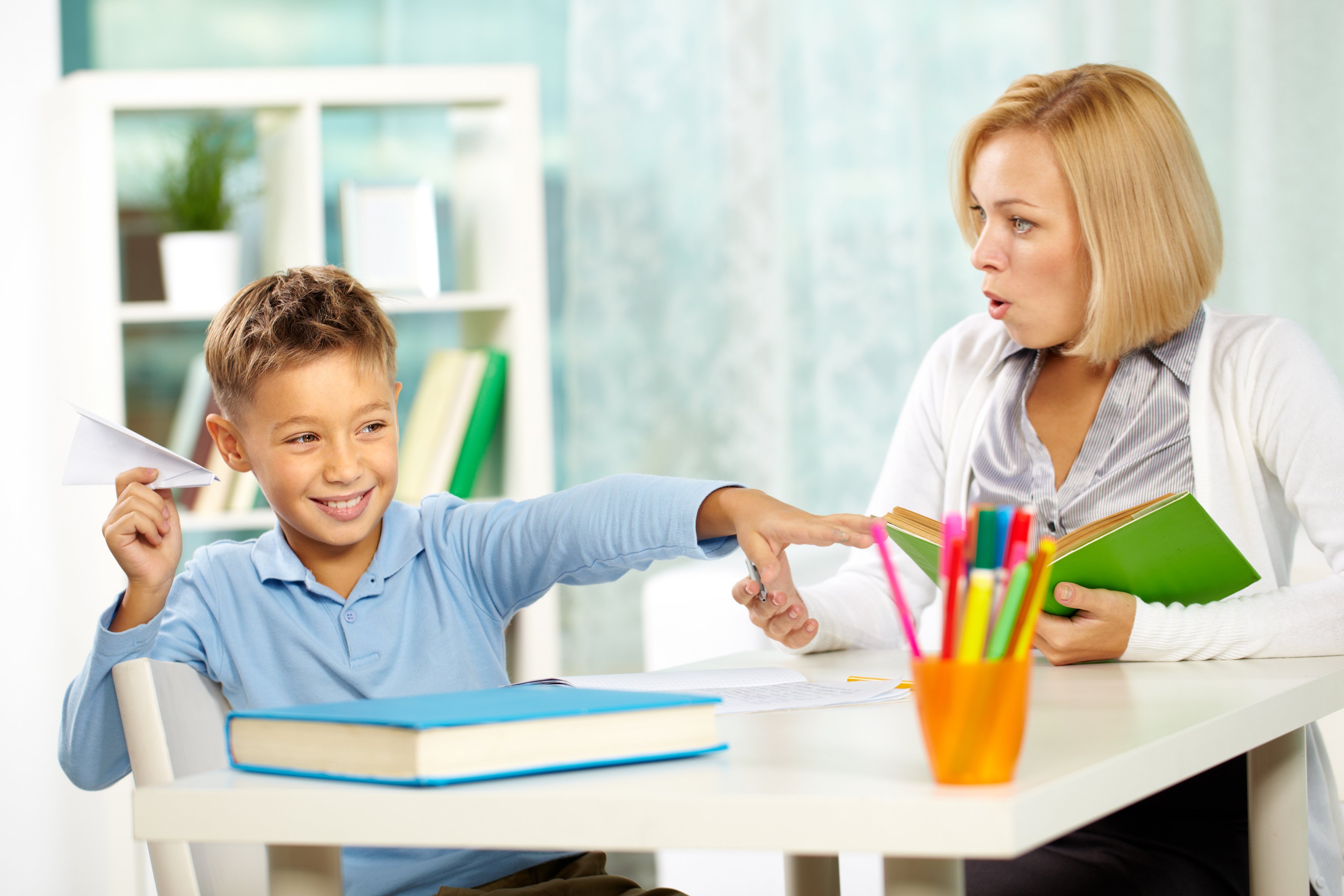 Graphicstock portrait of naughty boy playing with paper plane at workplace and his indignant tutor looking at him ra8BUZRJVb