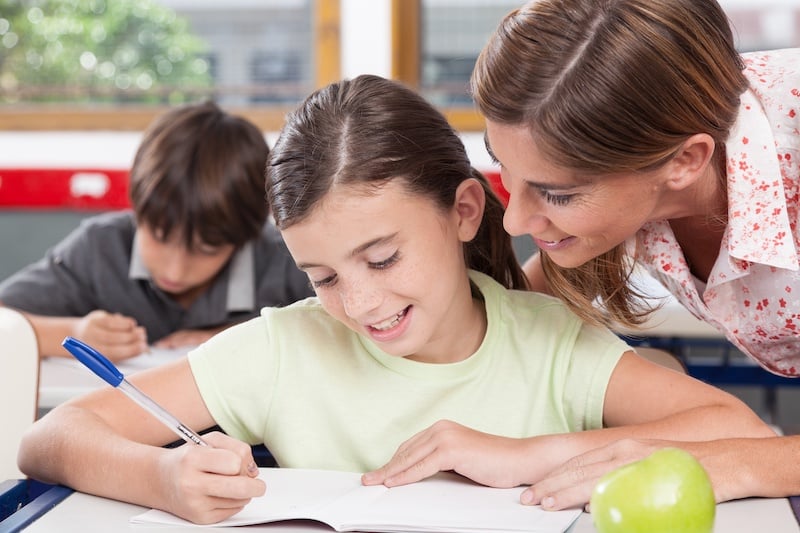 Teacher helping a girl in the classroom rjgXdqhALx